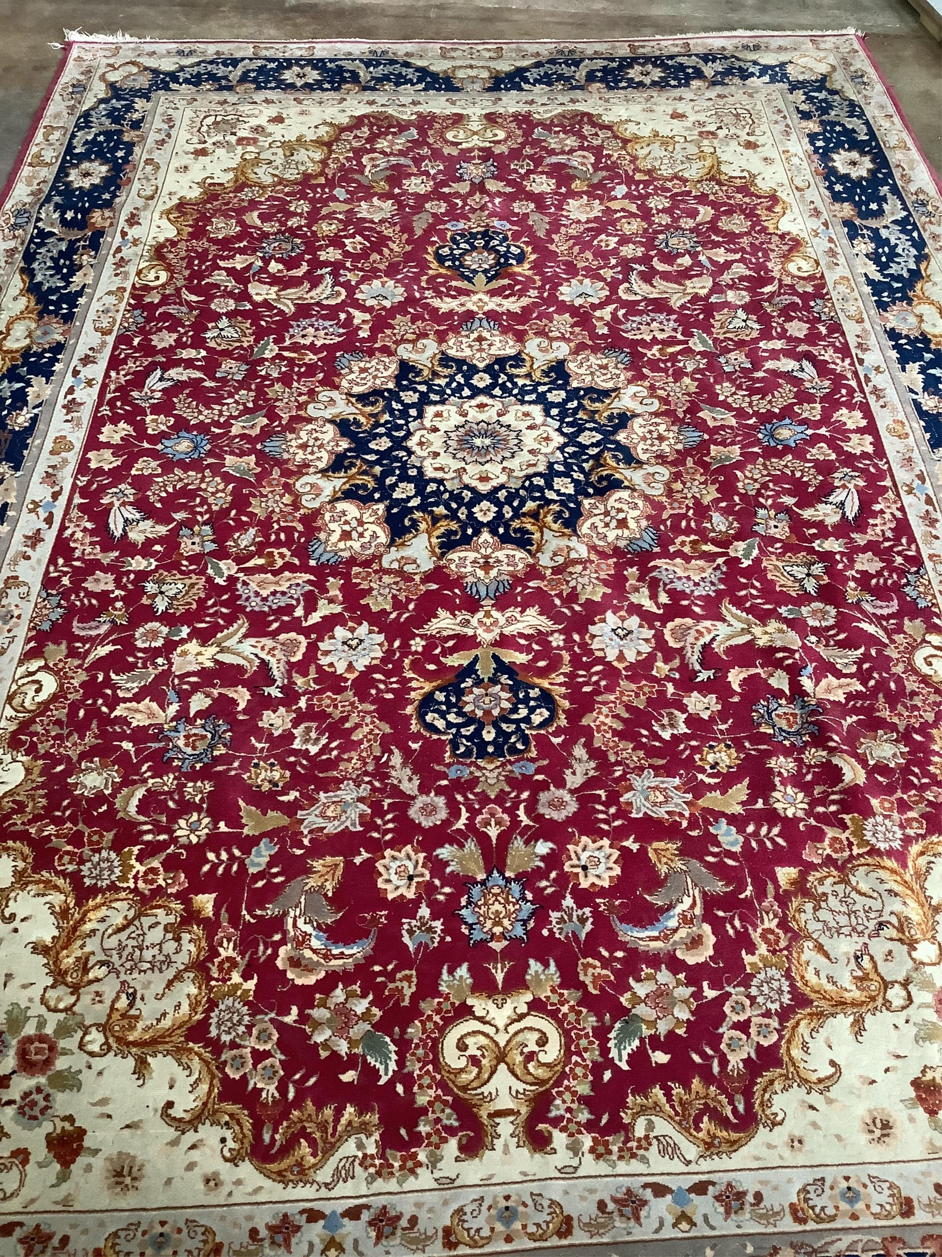 A Tabriz burgundy ground carpet, 300 x 200cm. Condition - fair